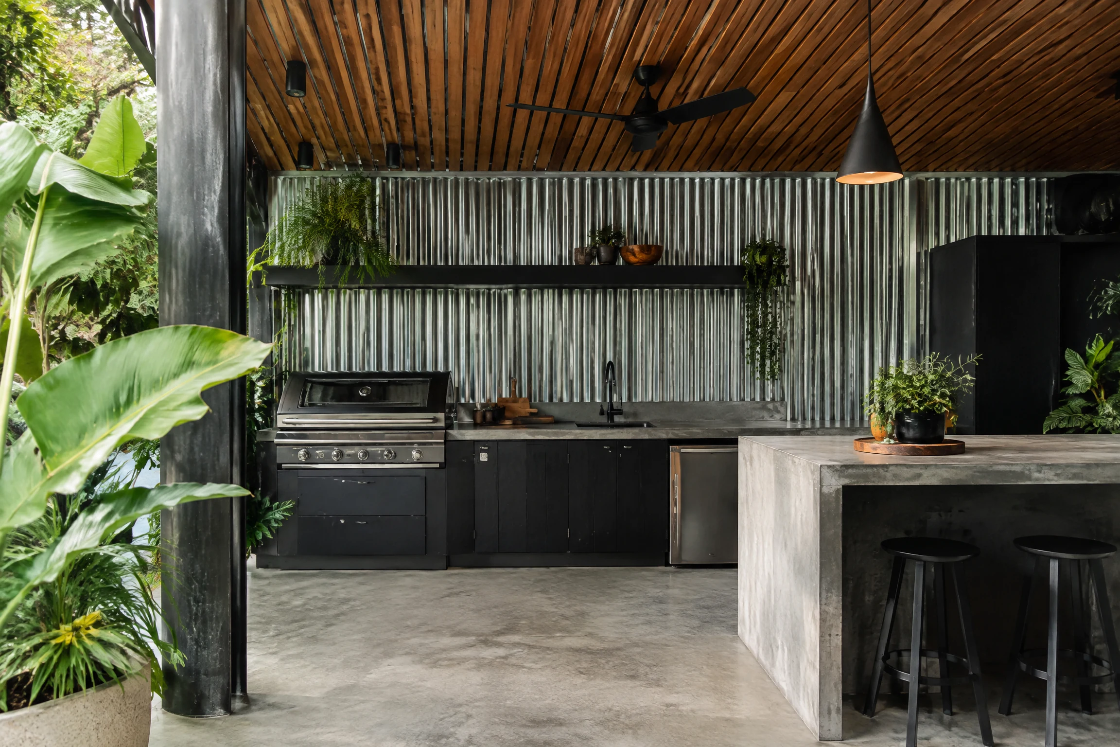 Industrial-chic outdoor kitchen with corrugated metal siding and black steel